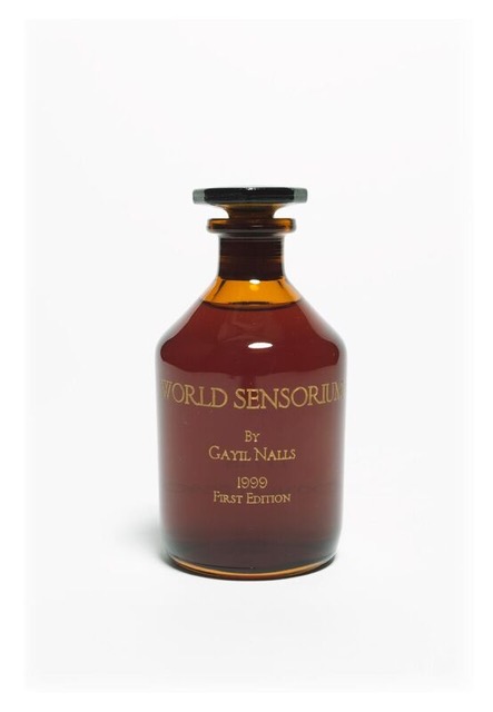 Photo of a brown class bottle etched in gold with the text, "WORLD SENSORIUM by Gayil Nalls, 1999 First Edition
