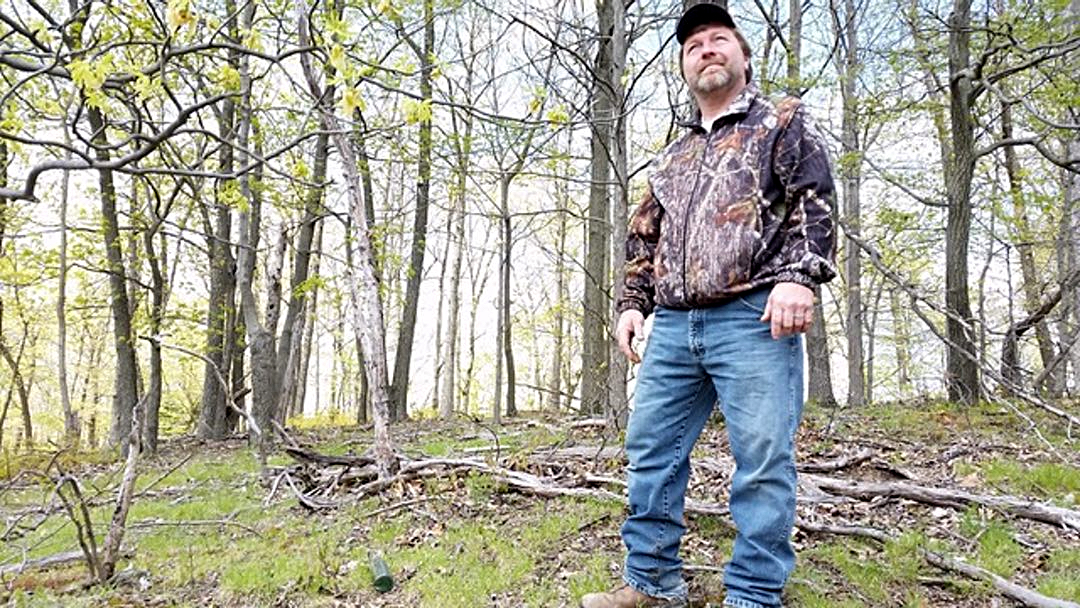 Photo of a man standing in a forest