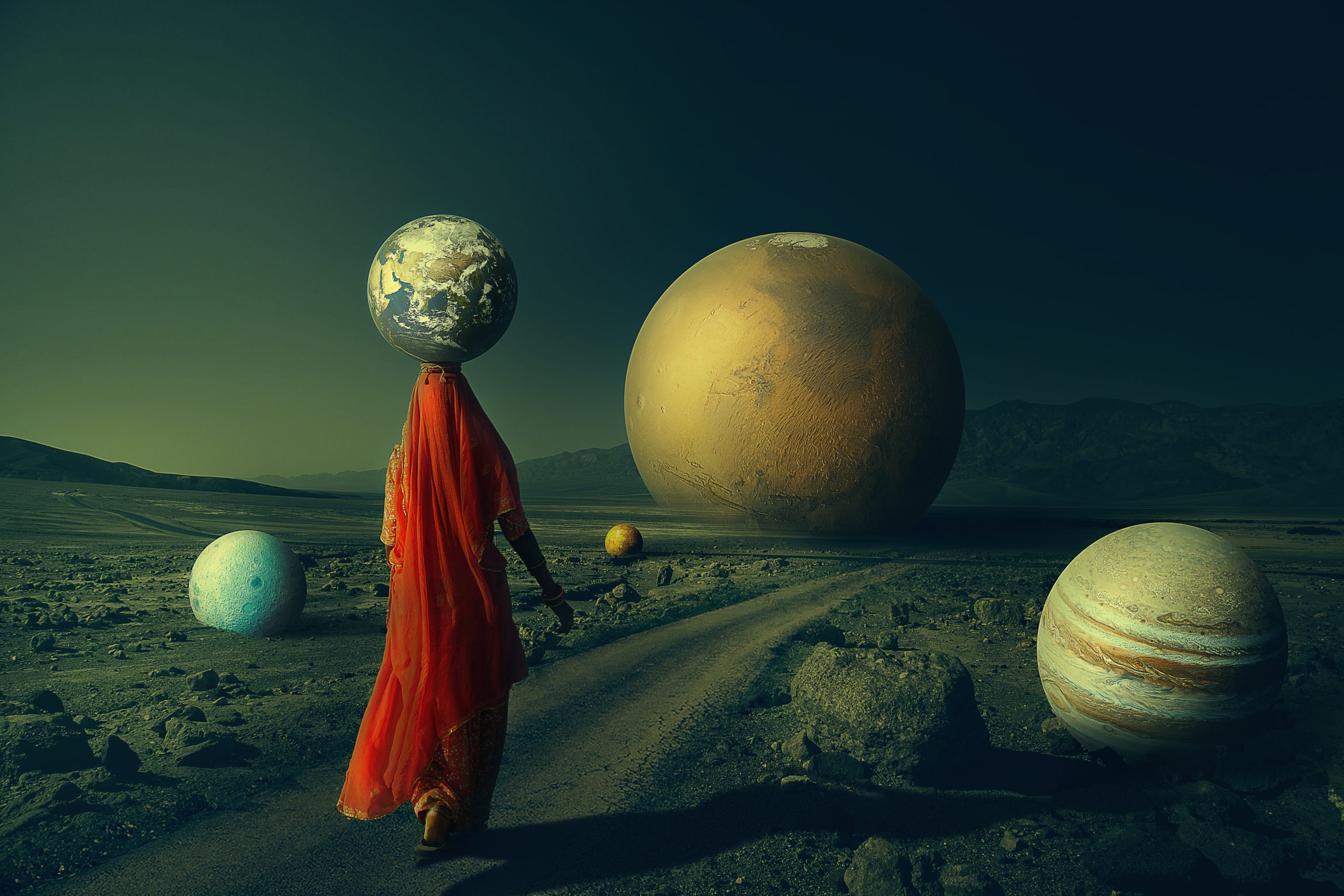 Stylized photo of a woman walking through a rugged desert, surrounded by planets, with the planet earth balanced on her head
