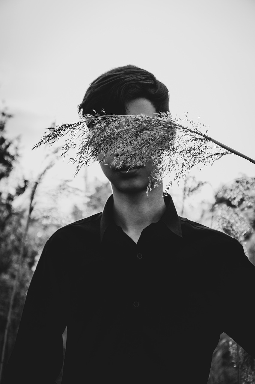 young man teen smelling grass reeds